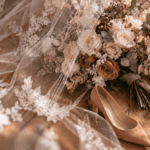 Spitzenschleier, Brautstrauß in Creme, Blush und Karamell und Blush-Pumps auf Holzboden, Rustic Romance Hochzeit